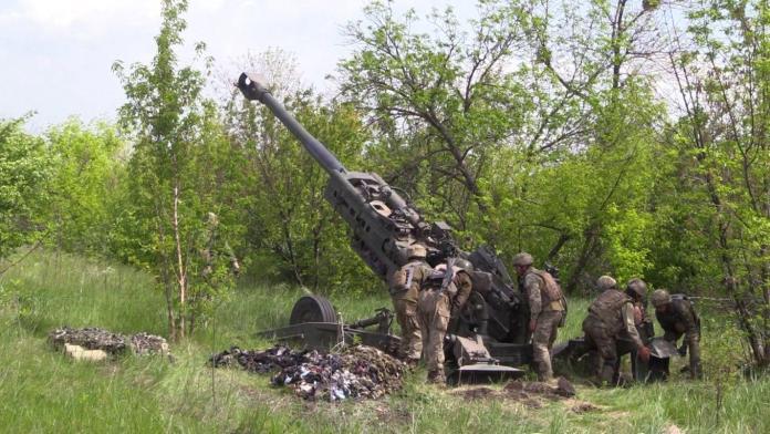 A group of soldiers standing next to a cannon Description automatically generated