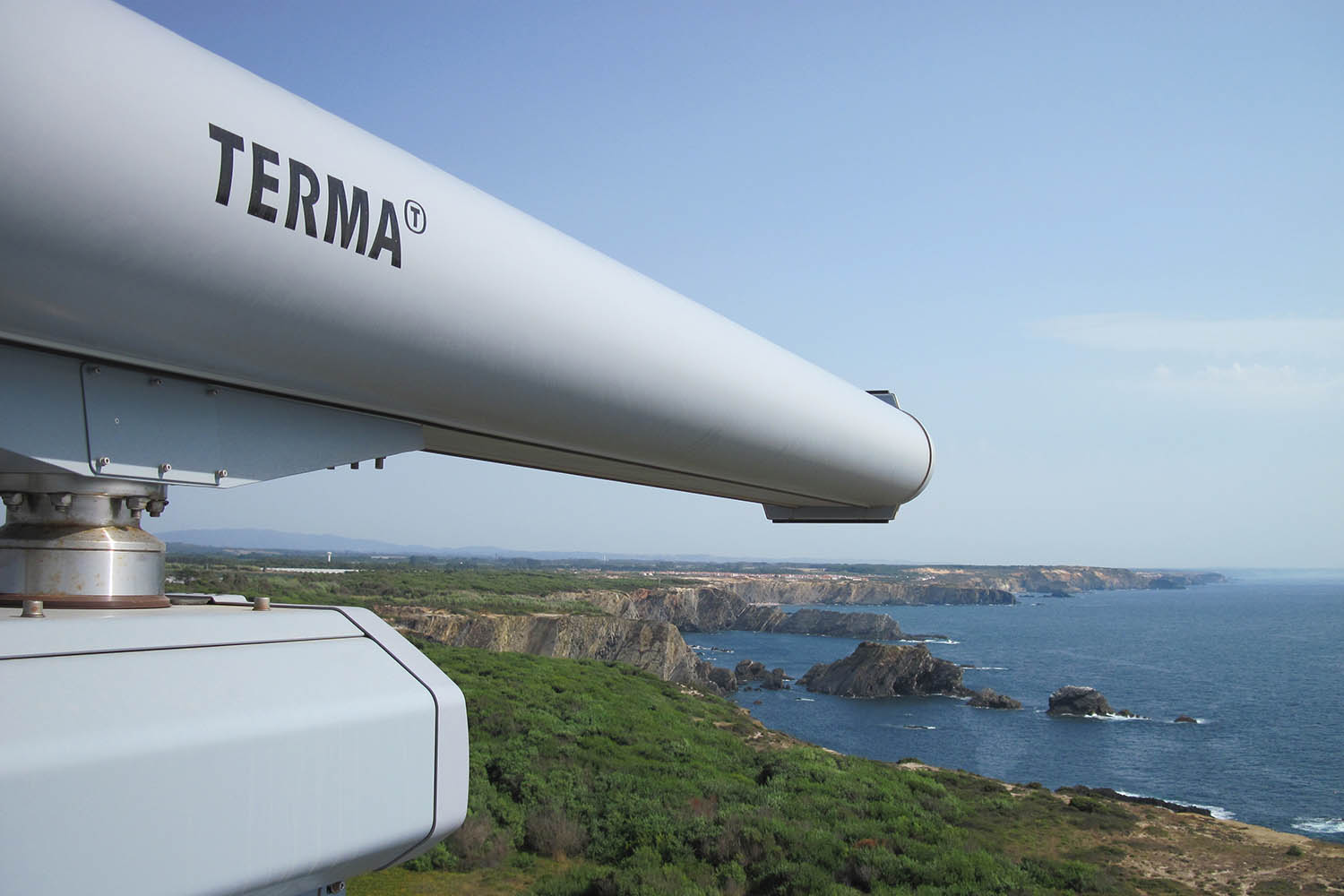 A long white telescope on a hill overlooking a body of water

Description automatically generated with medium confidence