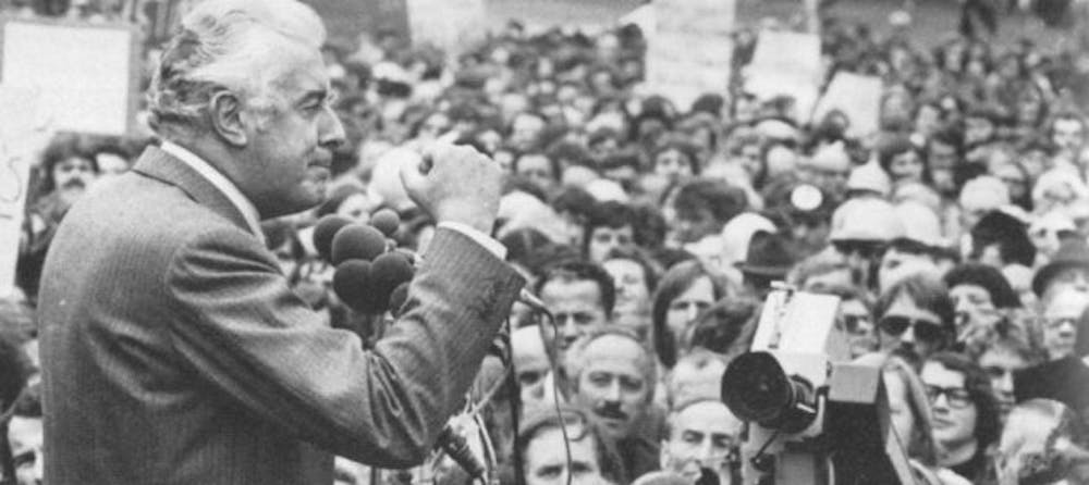 A person speaking into microphones in front of a crowd

Description automatically generated