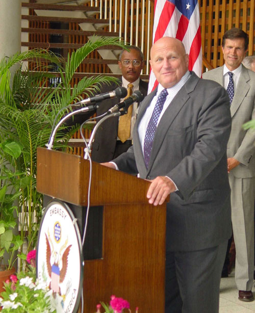 A person standing at a podium with microphones

Description automatically generated