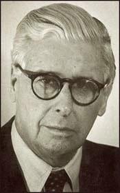 A person wearing glasses and a suit

Description automatically generated