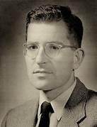 A person wearing glasses and a suit

Description automatically generated