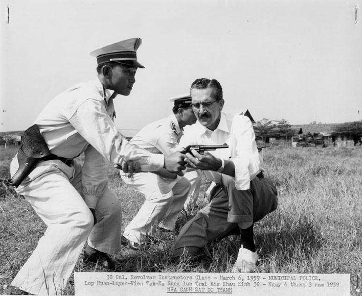 An MSUG instructor helps a Vietnamese municipal police offiver on his technique with a .38-caliber revolver, March 6, 1959.