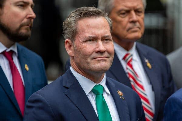 Representative Michael Waltz wearing a dark suit and green tie.