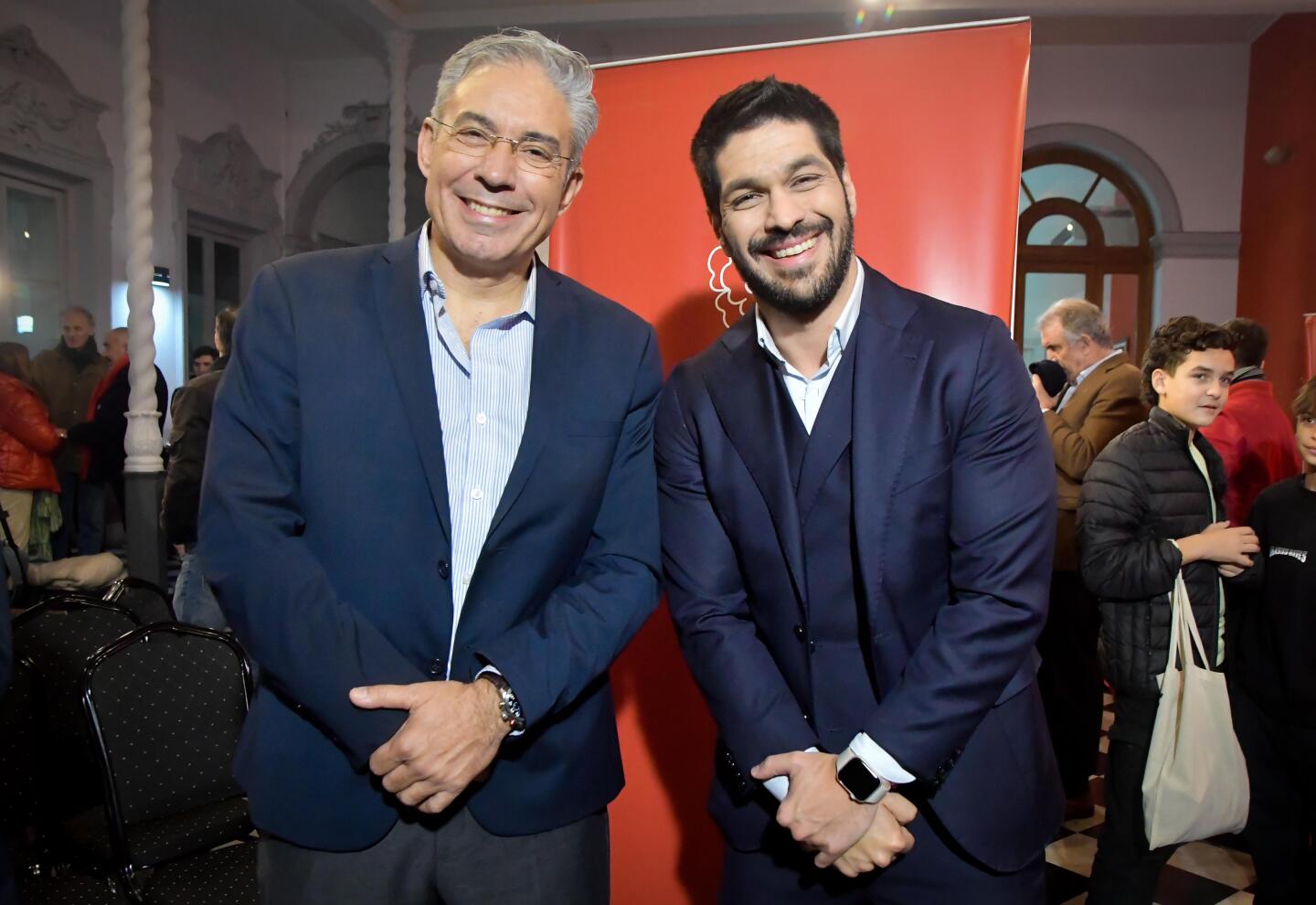 Two men in suits smiling

Description automatically generated