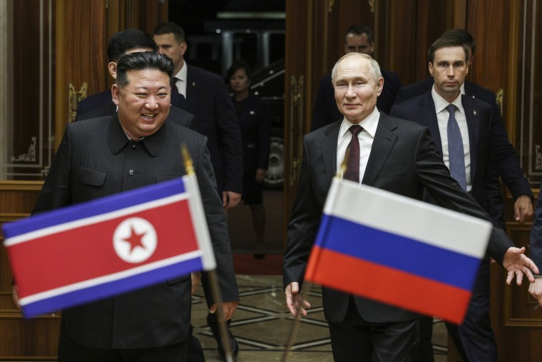 A group of men walking with flags

Description automatically generated