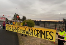 Peace Activists Try and Block Arms Supplies to Israel A group of people holding a yellow banner Description automatically generated
