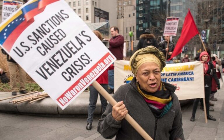 A person holding a sign

Description automatically generated
