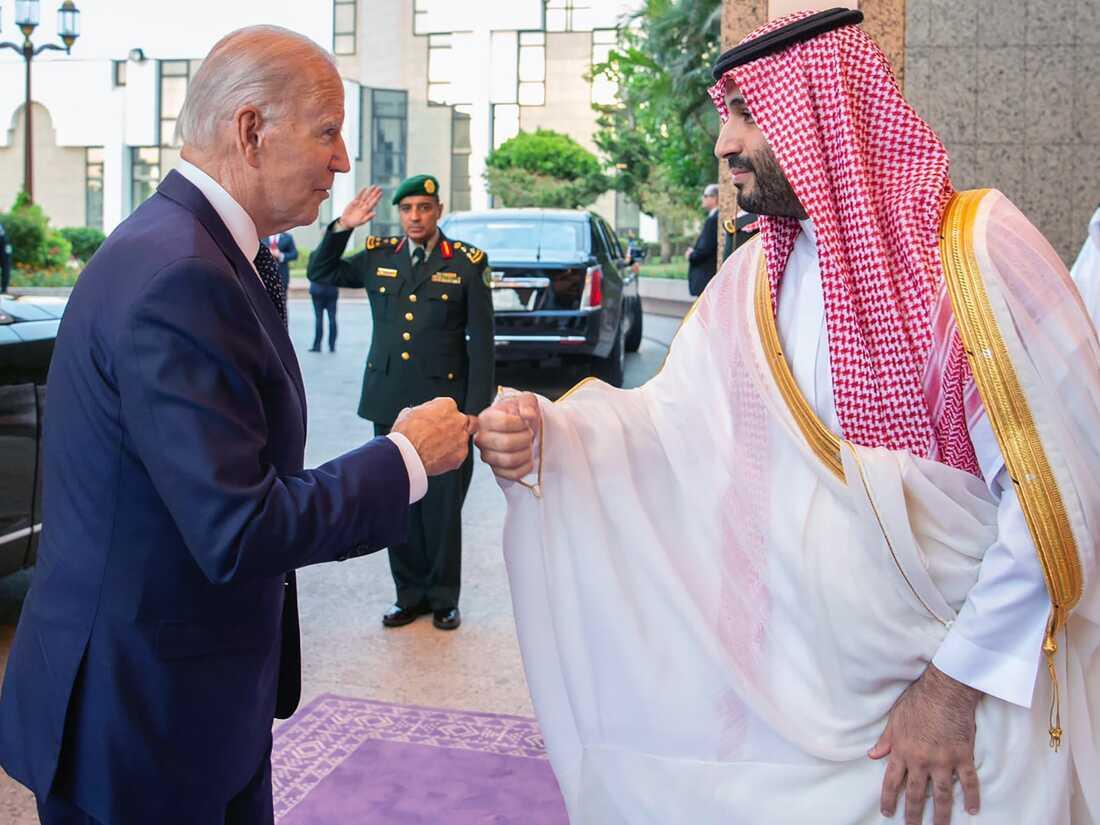 A person in a suit shaking hands with a person in a suit
Description automatically generated