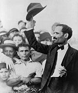 A person raising his hat up

Description automatically generated