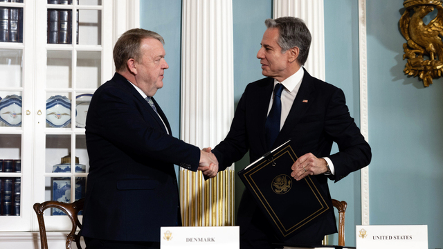 A person shaking hands with another person<br><br>Description automatically generated