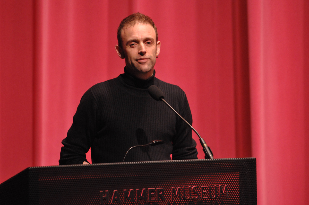 A person standing at a podium

Description automatically generated