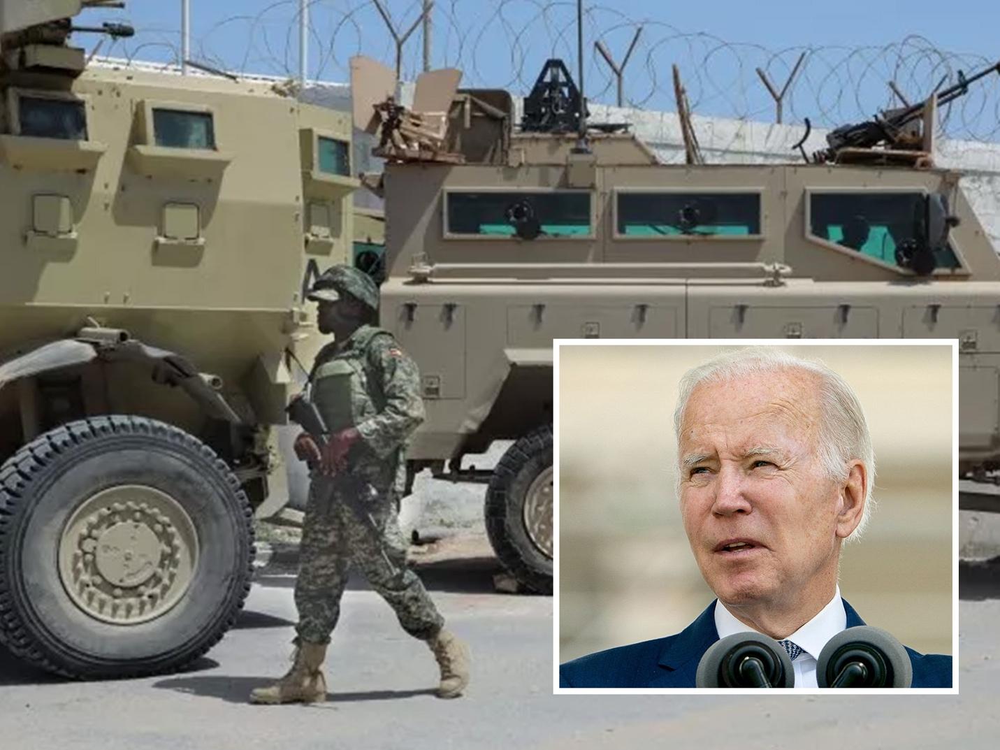 A person walking in front of a military vehicle
Description automatically generated