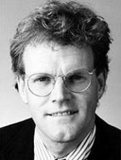 A person wearing glasses and a suit
Description automatically generated