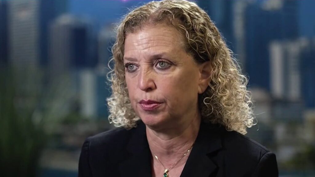 A person with curly blonde hair Description automatically generated