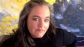 A person with long hair and a black shirt
Description automatically generated