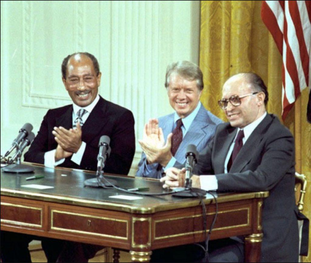 A group of men clapping at a desk

Description automatically generated