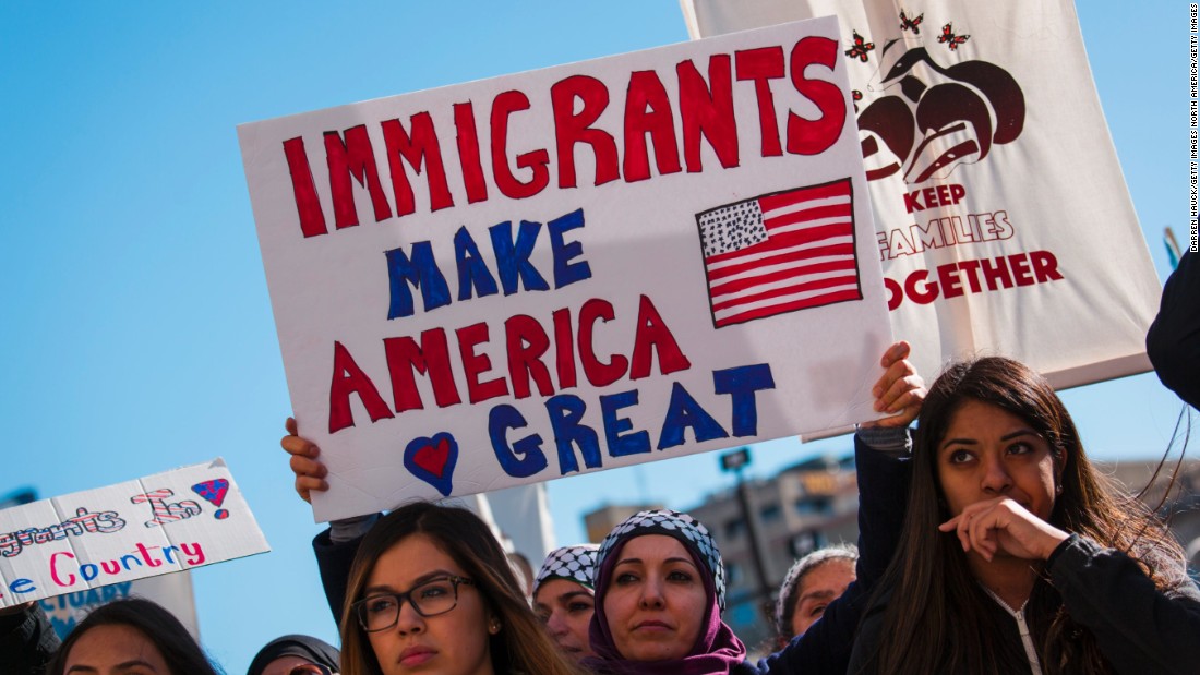 A group of people holding a sign
Description automatically generated
