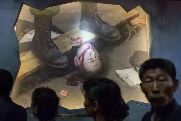 A group of people looking at a painting

Description automatically generated