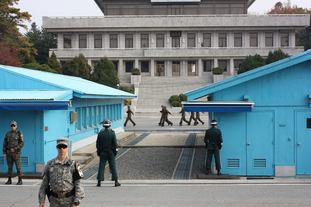 A group of soldiers walking in front of a building

Description automatically generated