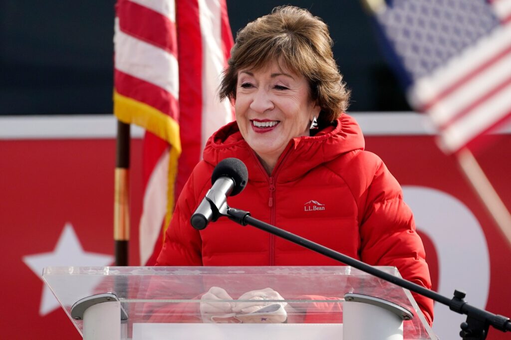 A person standing at a podium with a microphone

Description automatically generated