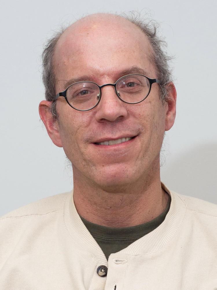 A person wearing glasses and a white sweater

Description automatically generated