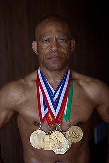 A person with medals around his neck

Description automatically generated