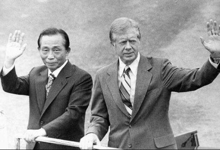 South Korean President Park Chung-hee, left, waves hand with his U.S. counterpart Jimmy Carter during a welcoming ceremony for the latter's Seoul visit in June, 1979. Korea Times file