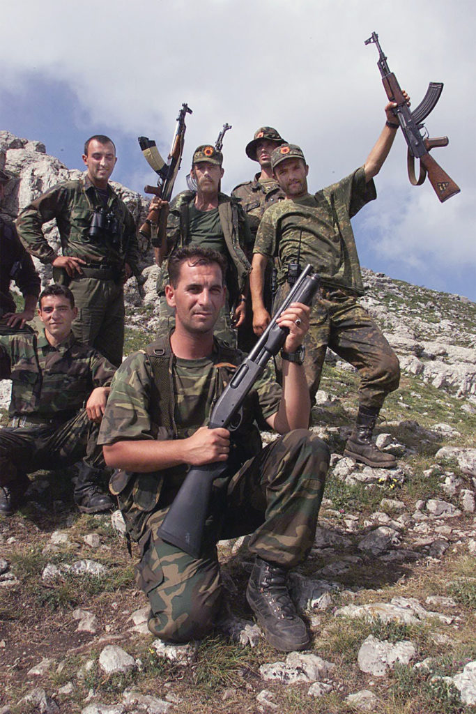 A group of men in military uniforms holding guns

Description automatically generated