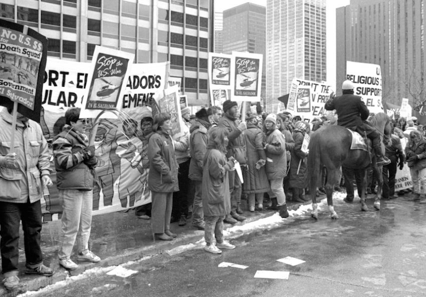 A group of people protesting in a city
Description automatically generated