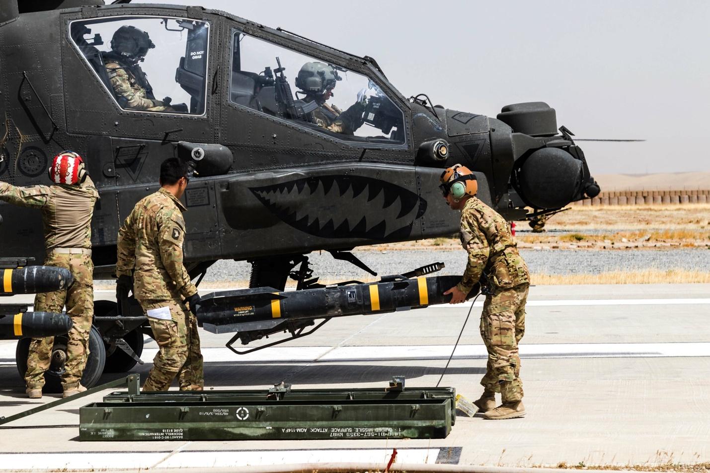 A group of soldiers loading a missile
Description automatically generated