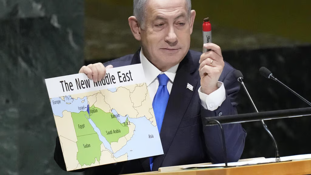 A person holding a sign and a marker Description automatically generated