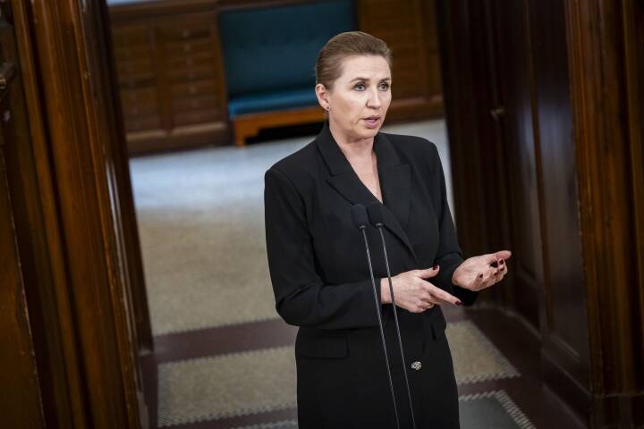 A person in a black suit standing in front of a microphone
Description automatically generated