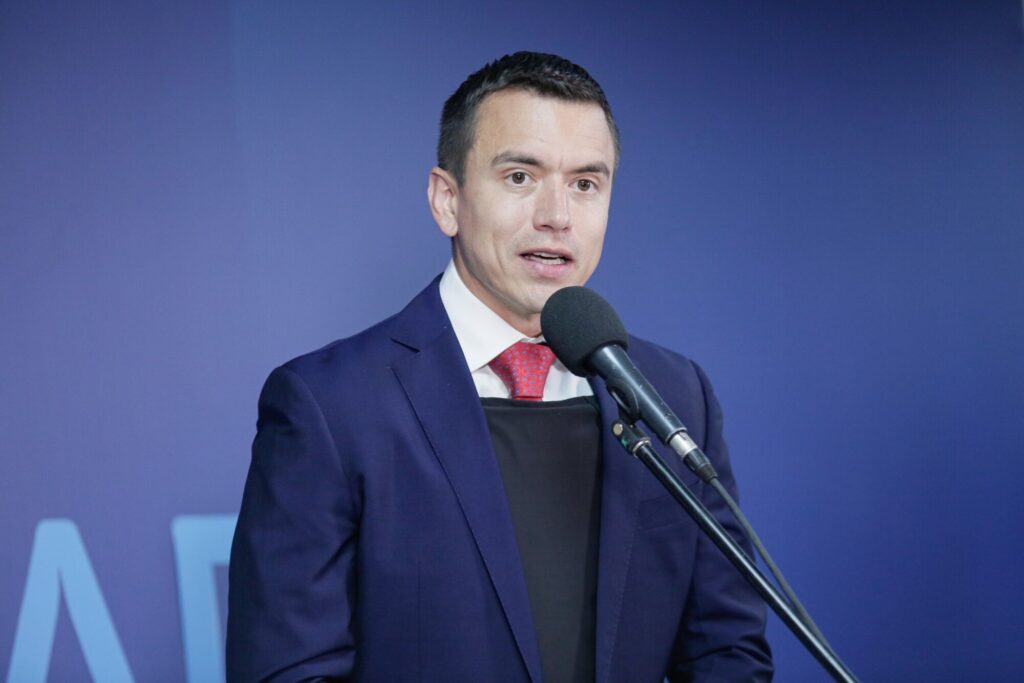 A person in a suit speaking into a microphone

Description automatically generated