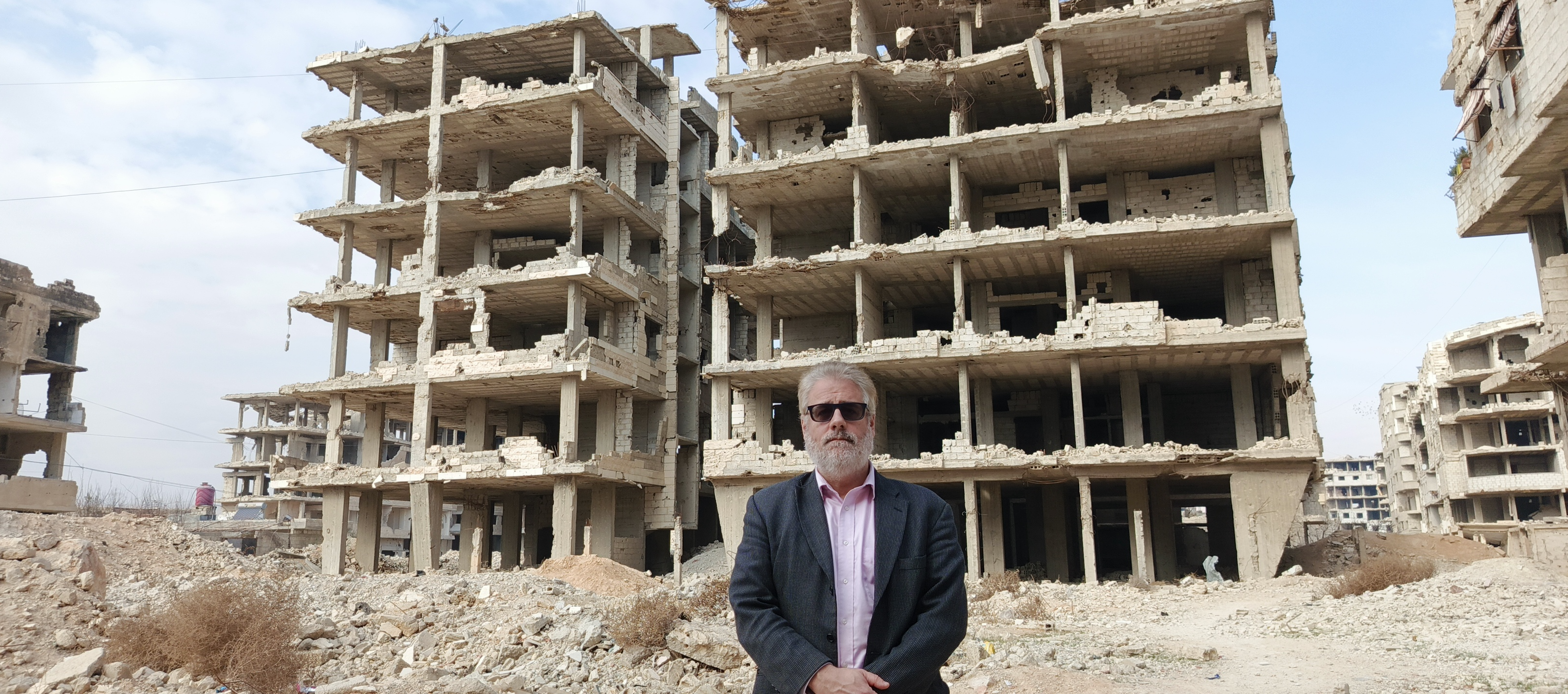 A person standing in front of a building
Description automatically generated