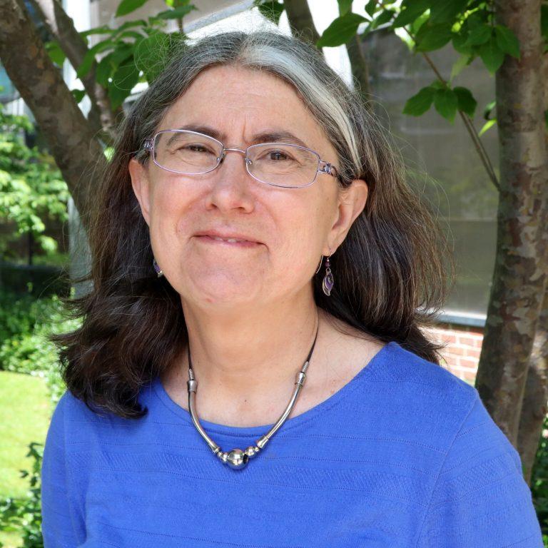 A person wearing glasses and a blue shirt
Description automatically generated