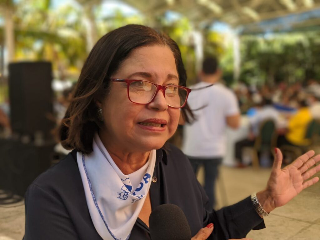 A person with glasses talking into a microphone

AI-generated content may be incorrect.