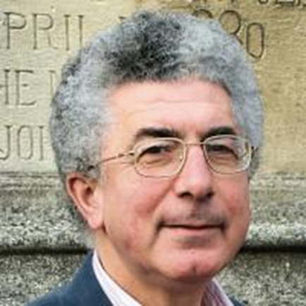 A person with grey hair wearing glasses Description automatically generated