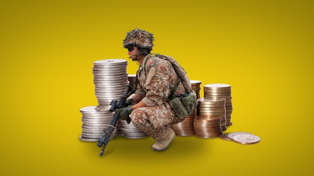 A soldier kneeling next to stacks of coins
Description automatically generated