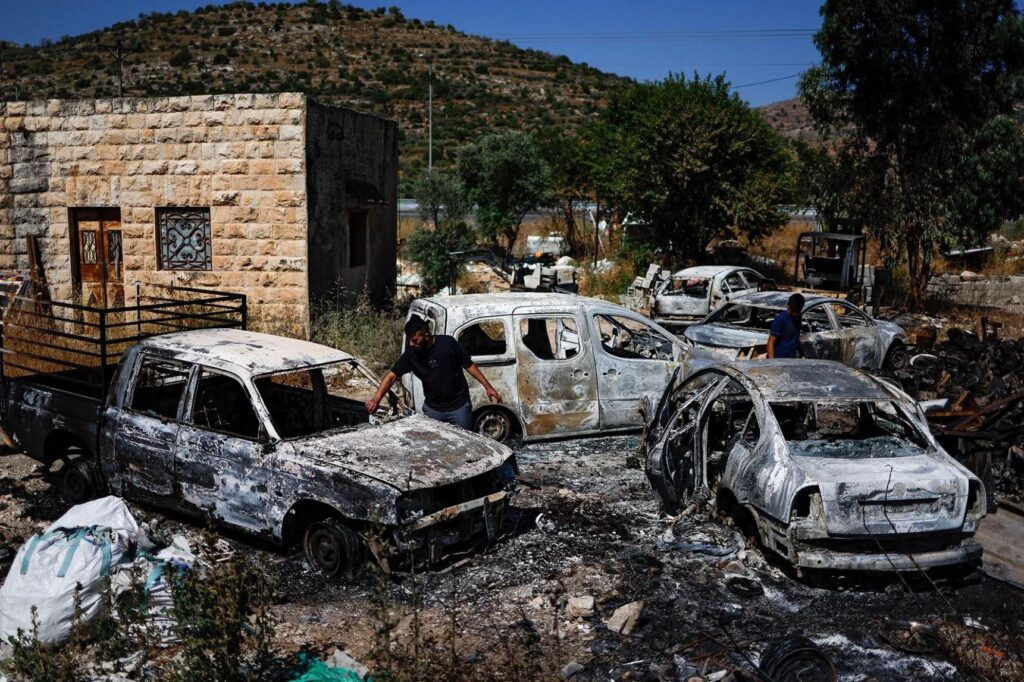 Several burnt cars in a junkyard Description automatically generated