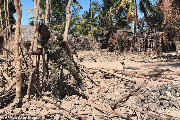 A Mozambican army soldier examines a village after it was attacked by jihadists in 2018