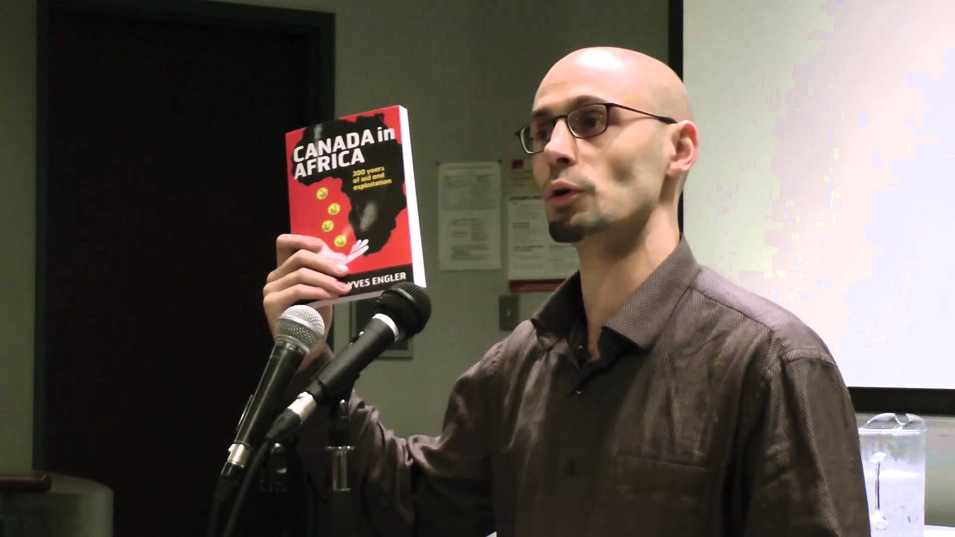 A person holding a book and speaking into a microphone

AI-generated content may be incorrect.