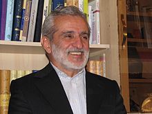 A person in a suit smiling

Description automatically generated