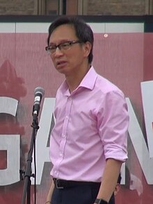 A person standing in front of a microphone

AI-generated content may be incorrect.