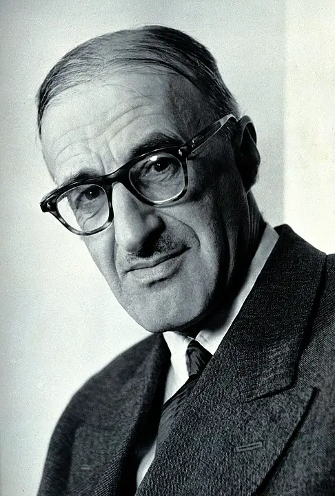 A person wearing glasses and a suit

Description automatically generated