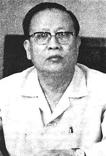 A person wearing glasses and a white shirt
Description automatically generated