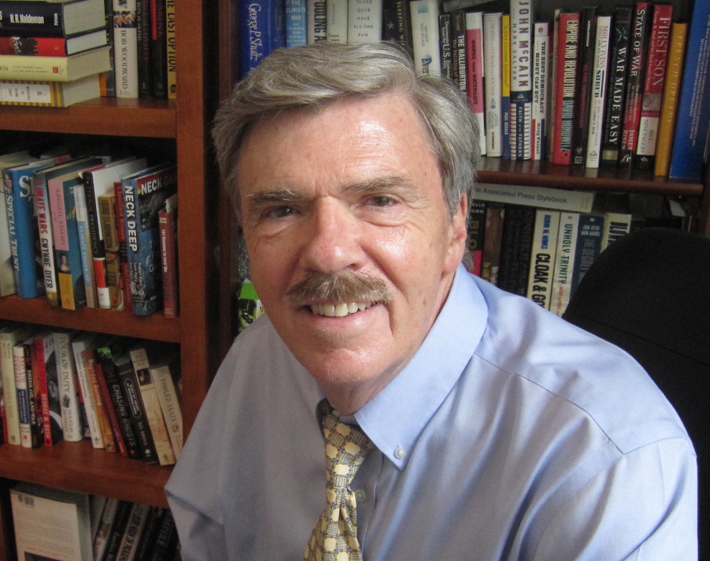 A person with a mustache smiling

Description automatically generated