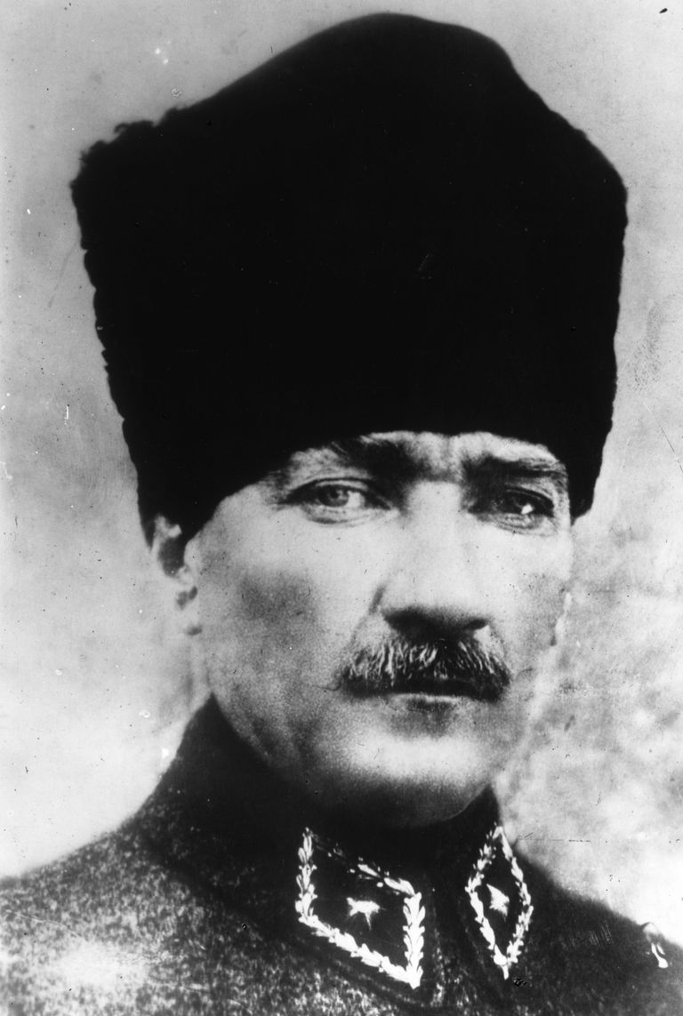 A person with a mustache wearing a black hat
Description automatically generated