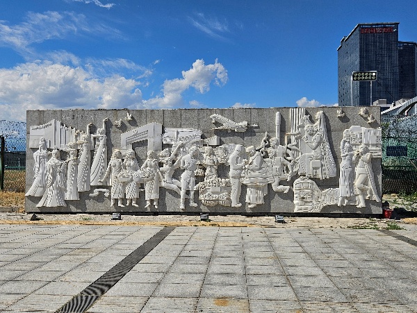 A stone wall with a group of people on it AI-generated content may be incorrect.