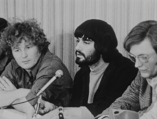 A group of men sitting next to microphones

Description automatically generated